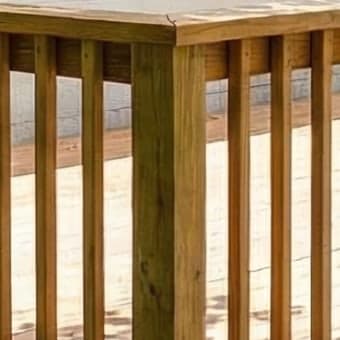 Close-up of the rendered deck: wood grain on the corner post, railing and shadows on the boards